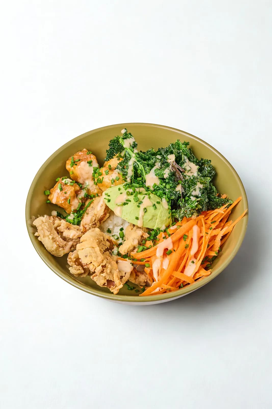 Bowl con Arroz de sushi, tofu a la naranja, orellanas apanadas, coliflor, zanahoria rallada, aguacate, kale crocante, cebollín y mayo sriracha.